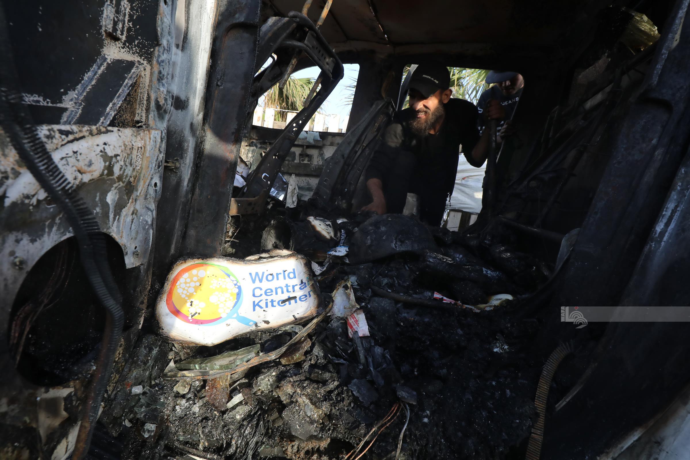 مواطنون يتفقدون مركبات موظفي منظمة "المطبخ المركزي العالمي" التي استهدفها الاحتلال على الطريق الساحلي غرب دير البلح- أرشيف "وفا"